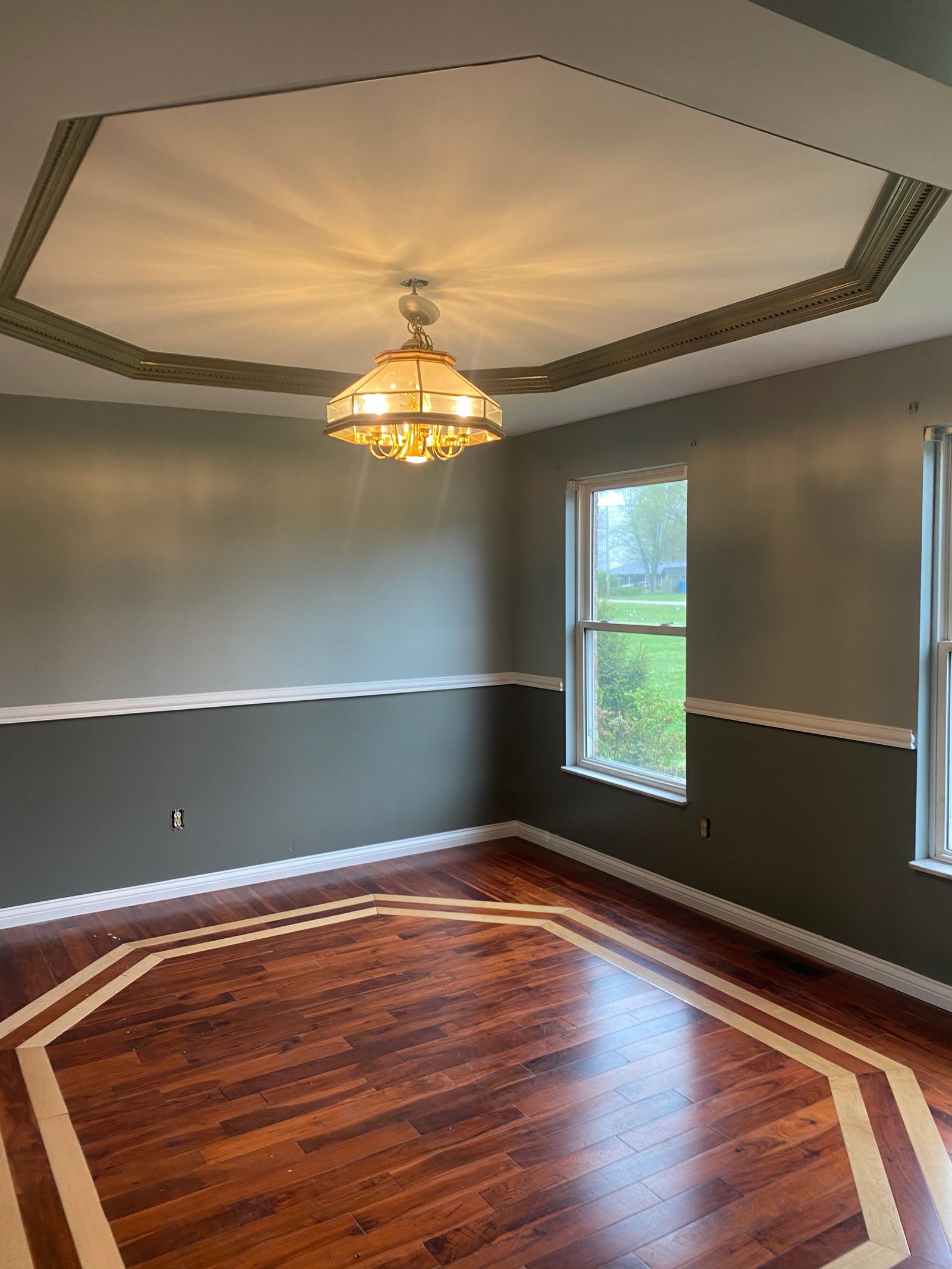 Finished interior room with tray ceiling and hardwood floor from Andrews Painting Company’s project gallery.